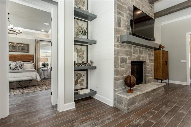 interior space with hardwood / wood-style floors, a notable chandelier, ornamental molding, and a fireplace