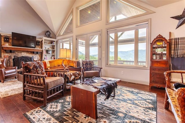 living room featuring a fireplace, dark wood-type flooring, and a wealth of natural light