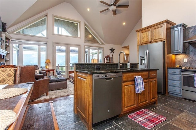 kitchen with stainless steel appliances, ceiling fan, plenty of natural light, and a kitchen island with sink