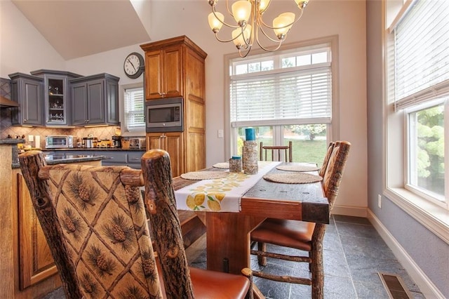 dining space with lofted ceiling and a chandelier