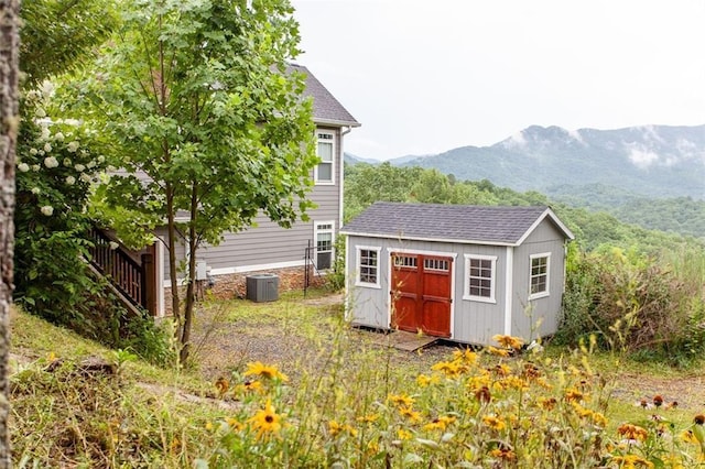 view of outdoor structure with a mountain view and central air condition unit