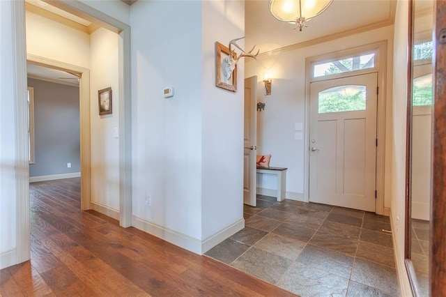 entryway featuring ornamental molding and dark hardwood / wood-style flooring