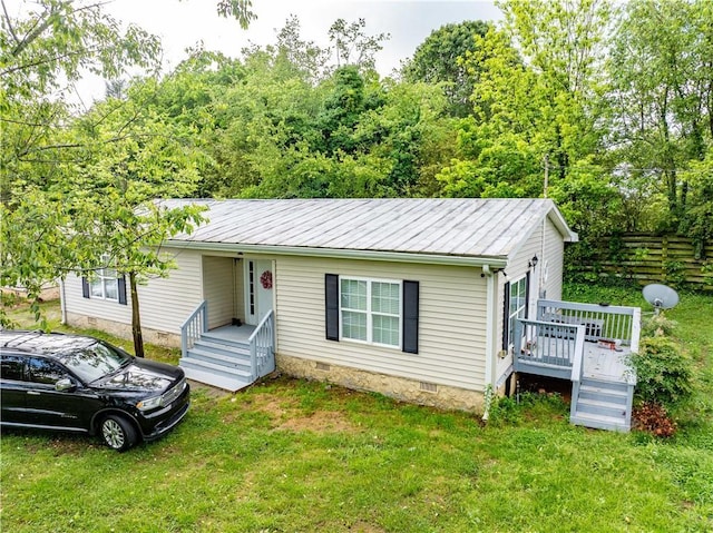 view of front of house with crawl space, a front lawn, a wooden deck, and metal roof