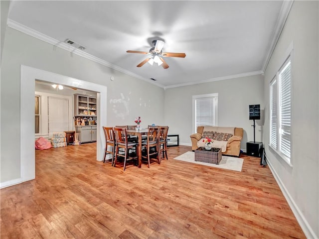 dining area featuring ceiling fan, light wood-style floors, ornamental molding, and baseboards