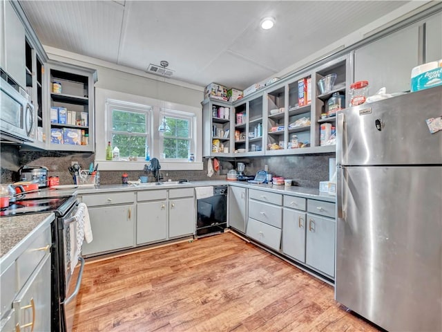 kitchen featuring stainless steel appliances, open shelves, a sink, tasteful backsplash, and recessed lighting