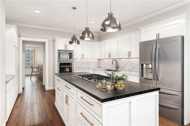 kitchen with sink, decorative light fixtures, a center island, stainless steel appliances, and white cabinets