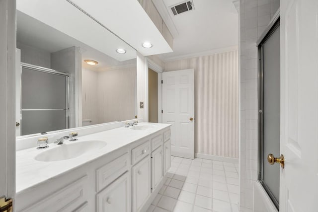 bathroom with vanity, tile patterned flooring, ornamental molding, and enclosed tub / shower combo