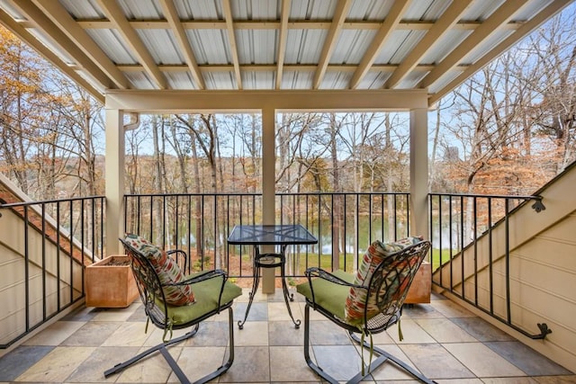 sunroom featuring a water view