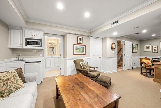 carpeted living room with ornamental molding and sink