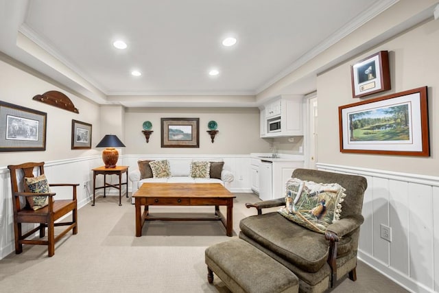 sitting room with light carpet, crown molding, and a raised ceiling