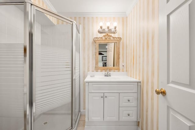 bathroom featuring vanity, a shower with door, and ornamental molding