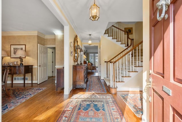 entrance foyer featuring hardwood / wood-style floors and crown molding