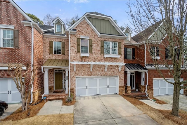 townhome / multi-family property with board and batten siding, brick siding, driveway, and an attached garage