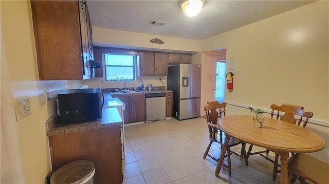 kitchen with sink, light tile patterned floors, and stainless steel appliances