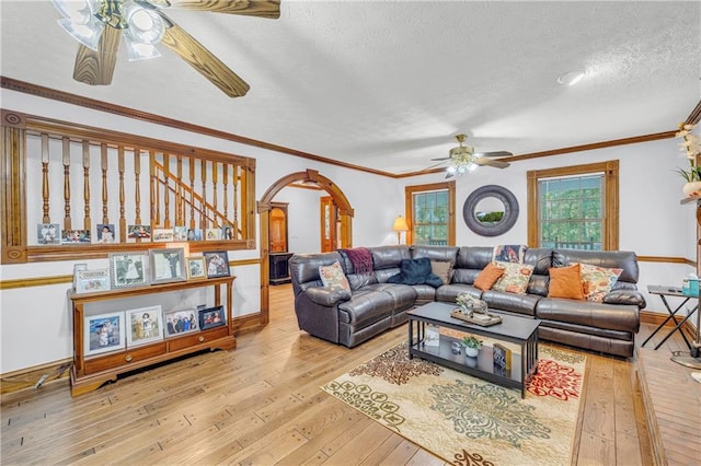 living room featuring crown molding, a textured ceiling, ceiling fan, and light hardwood / wood-style floors