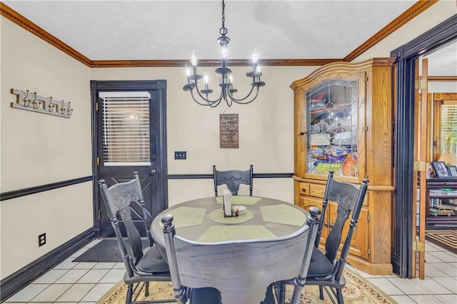 tiled dining room featuring a textured ceiling, ornamental molding, and a notable chandelier