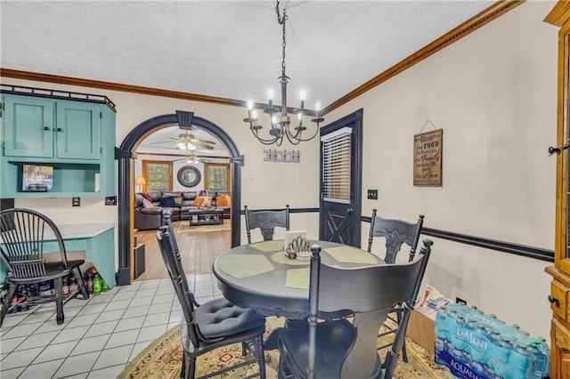 dining room featuring a textured ceiling, light hardwood / wood-style flooring, ornamental molding, and ceiling fan with notable chandelier