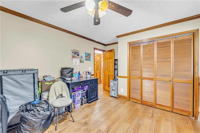 misc room with ceiling fan, a textured ceiling, crown molding, and light hardwood / wood-style flooring