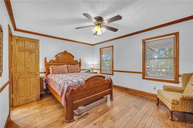 bedroom featuring a textured ceiling, light hardwood / wood-style flooring, ceiling fan, and ornamental molding