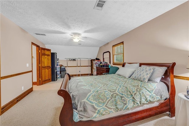 bedroom with light carpet, vaulted ceiling, a textured ceiling, and ceiling fan