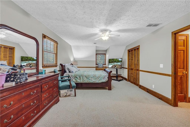 bedroom featuring multiple windows, ceiling fan, and a textured ceiling