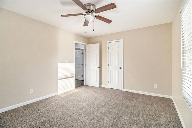 unfurnished bedroom featuring carpet flooring, a ceiling fan, and baseboards