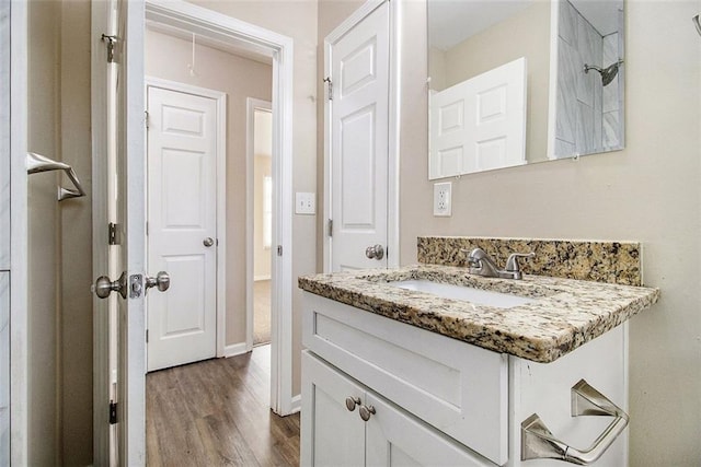 bathroom featuring vanity, baseboards, and wood finished floors