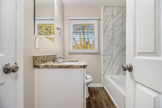 full bathroom with baseboards, toilet, wood finished floors, and vanity