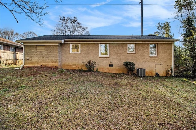 back of house featuring a yard, fence, brick siding, and crawl space