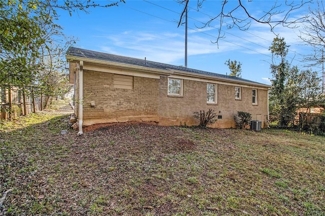 back of property with brick siding, central AC, and fence