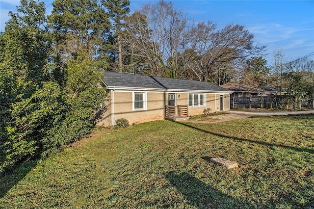 view of front of property featuring a front yard, fence, and stucco siding