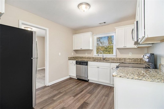 kitchen featuring a sink, baseboards, appliances with stainless steel finishes, white cabinetry, and dark wood-style flooring