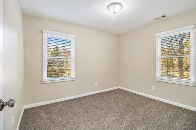 unfurnished room with visible vents, baseboards, and carpet floors