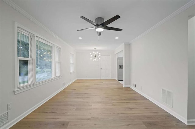 empty room with ceiling fan with notable chandelier, crown molding, and light hardwood / wood-style floors