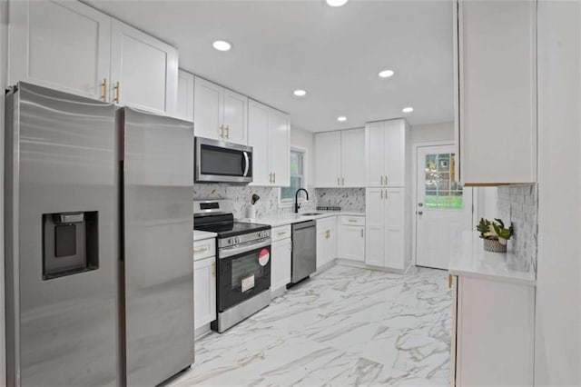 kitchen featuring sink, white cabinets, decorative backsplash, and appliances with stainless steel finishes