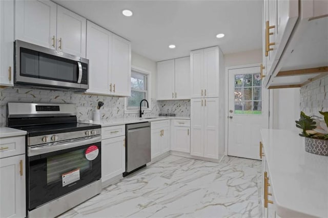 kitchen with tasteful backsplash, white cabinetry, a wealth of natural light, and stainless steel appliances