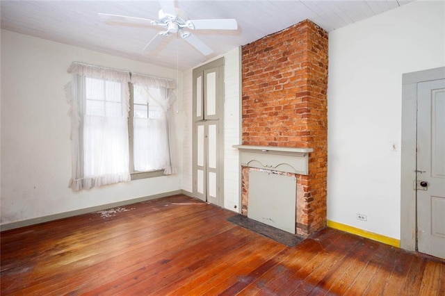 unfurnished living room with a brick fireplace, wood-type flooring, and ceiling fan