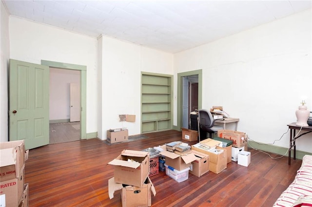 interior space with built in shelves and dark wood-type flooring