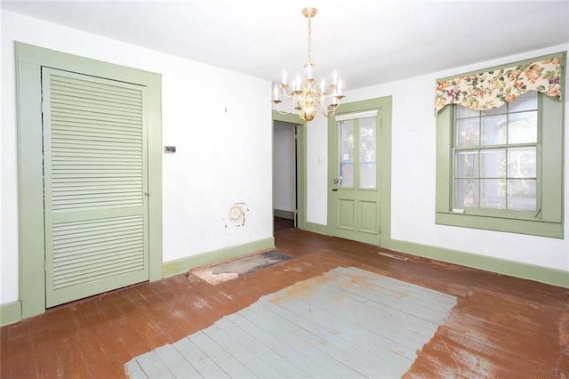 unfurnished dining area with dark hardwood / wood-style floors and a chandelier