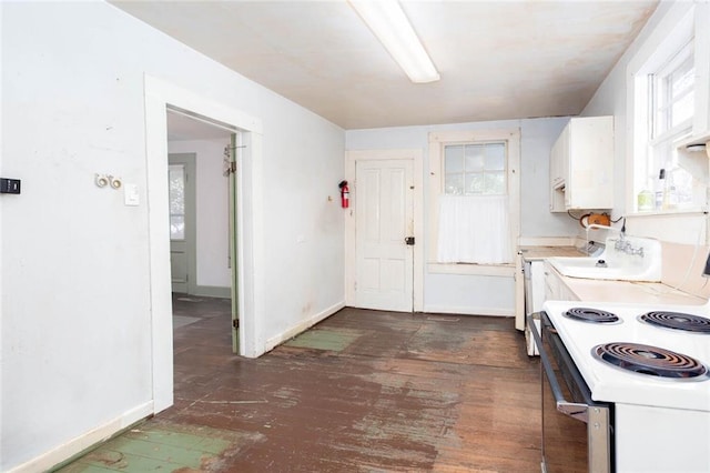 kitchen featuring washer / clothes dryer, dark hardwood / wood-style floors, white cabinets, and white range with electric cooktop