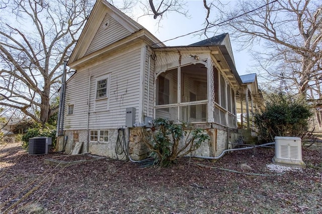 view of home's exterior featuring central AC unit and a sunroom