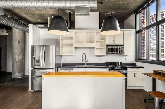 kitchen with dark wood-style floors, appliances with stainless steel finishes, wooden counters, and a sink
