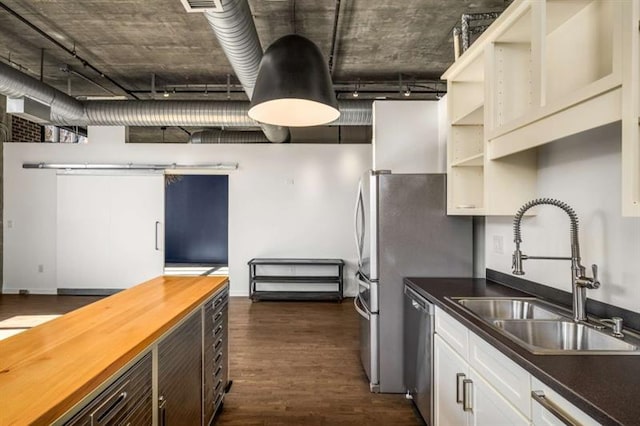 kitchen with open shelves, dark wood-type flooring, a sink, wood counters, and dishwasher