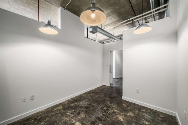 unfurnished dining area featuring baseboards and unfinished concrete floors