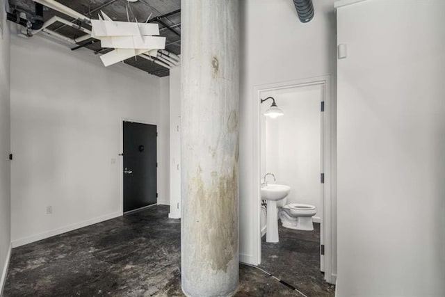 bathroom with concrete flooring and toilet
