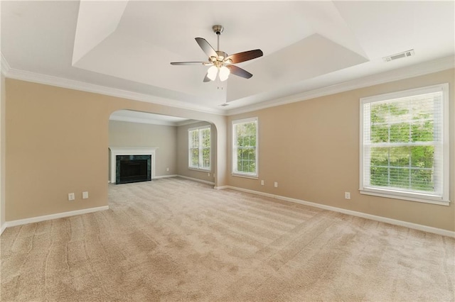 2154 Marne Gln NW, Kennesaw, GA 30152 - unfurnished living room featuring a raised ceiling, arched walkways, crown molding, plenty of natural light, and light colored carpet