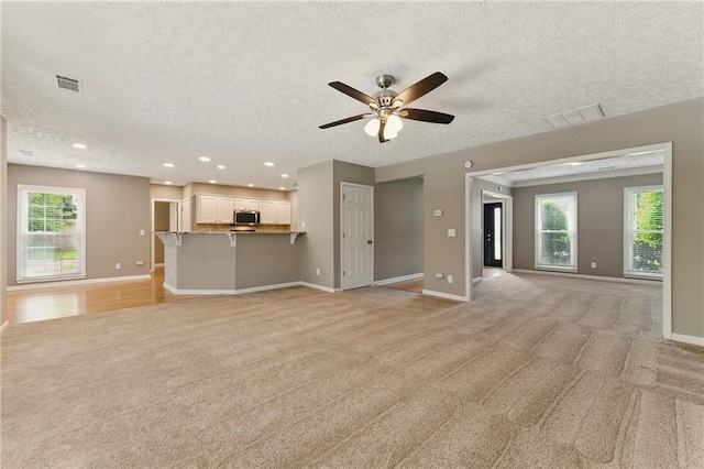 2154 Marne Gln NW, Kennesaw, GA 30152 - unfurnished living room with light colored carpet, baseboards, a textured ceiling, a ceiling fan, and recessed lighting