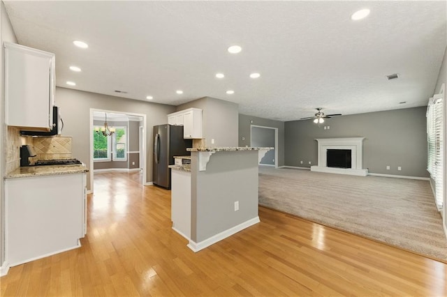 2154 Marne Gln NW, Kennesaw, GA 30152 - kitchen with appliances with stainless steel finishes, white cabinetry, baseboards, a ceiling fan, and a breakfast bar area