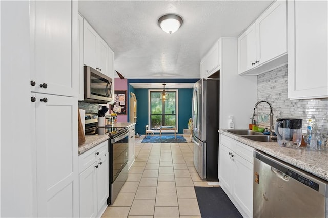 5360 Fieldgreen Dr, Stone Mountain, GA 30088 - kitchen with appliances with stainless steel finishes, a textured ceiling, white cabinetry, light tile patterned floors, and decorative backsplash