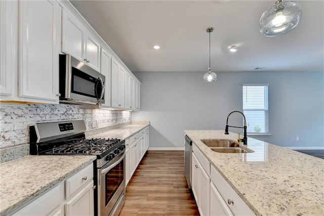 kitchen featuring light hardwood / wood-style floors, sink, stainless steel appliances, light stone countertops, and white cabinetry